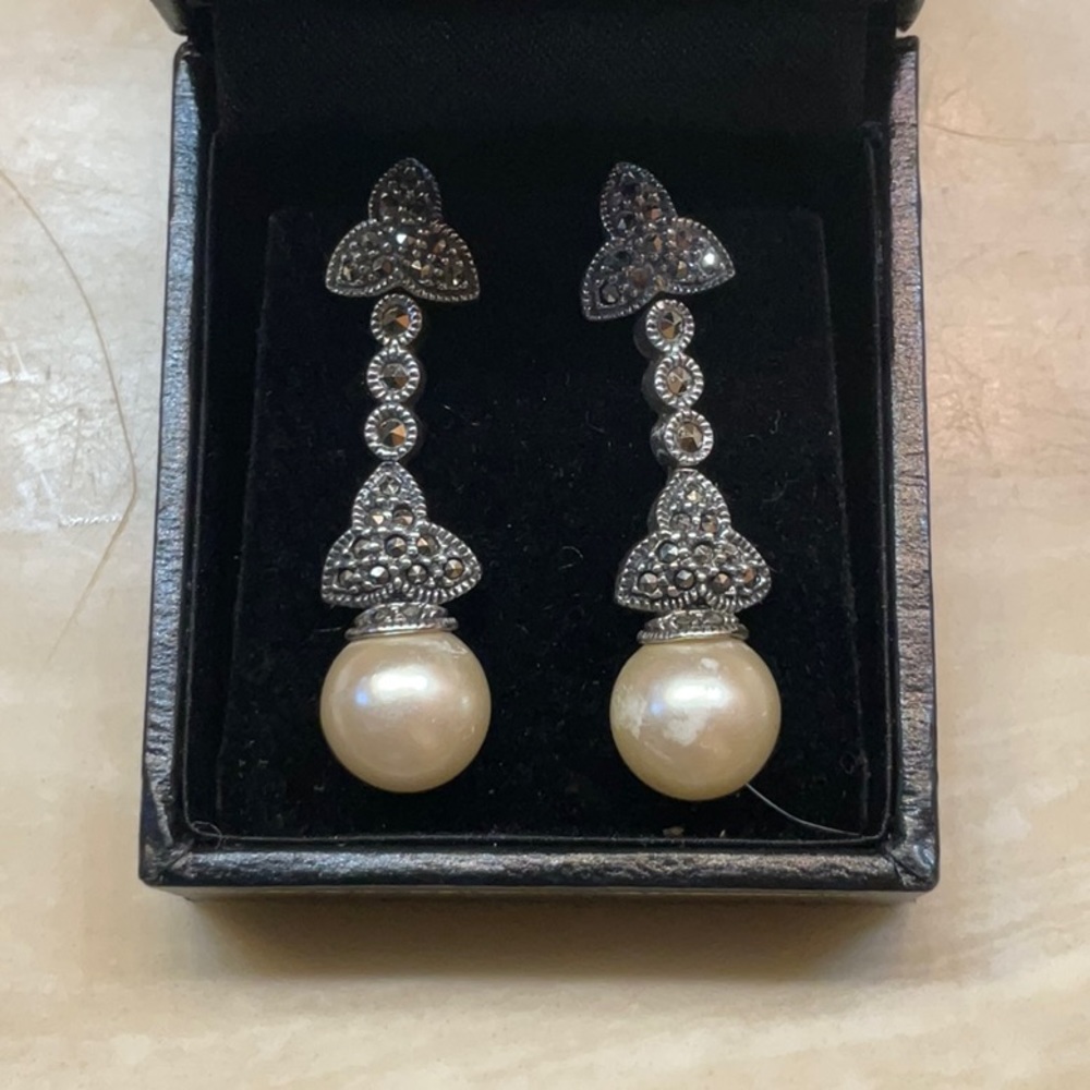 Sterling silver earrings with simulated dangling pearl.